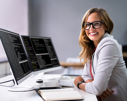 smiling woman at a desk with computer