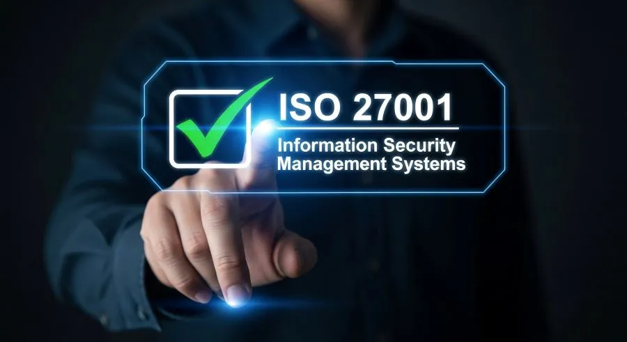 Hand holding a checkmark symbol representing ISO/IEC 27001:2022 certification achievement