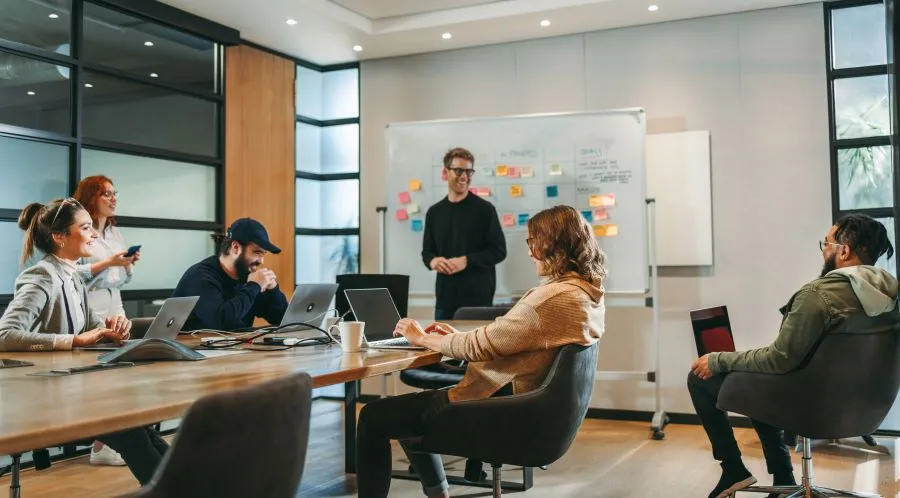Group of professionals planning website design with a vision board for managed hosting services