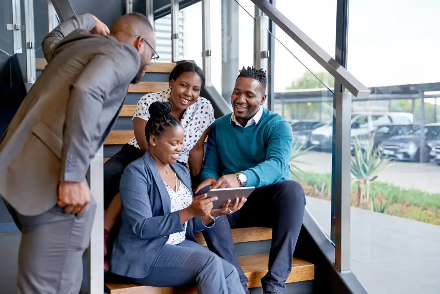 Pan-African business professionals collaborating on tablet representing consortium network across African countries.