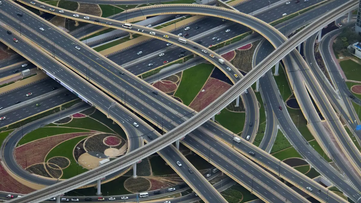 A multi level motorway interchange photographed from the air, its ramps crossing over one another.