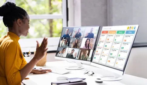 A Black woman in a yellow shirt on a video call