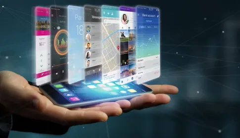 Hand holding a smartphone projecting enterprise mobile app interfaces including banking, messaging, maps and travel.