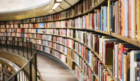 Curved shelves of a multi-level library filled with bound volumes.