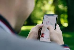 Traveler using a mobile map app to navigate a group trip itinerary