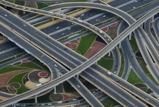 A multi level motorway interchange photographed from the air, its ramps crossing over one another.