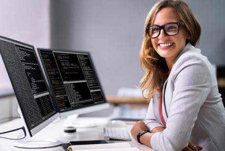 smiling woman at a desk with computer