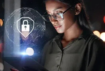 A woman in glasses looks at a tablet